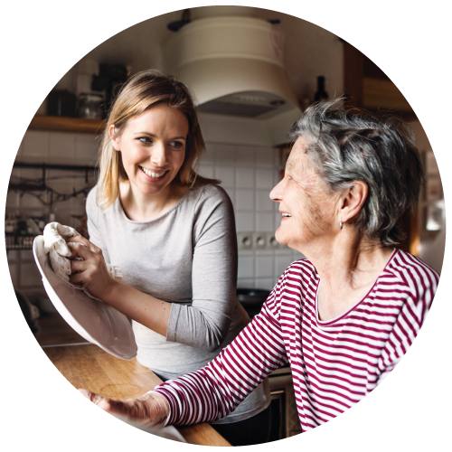 Aide assists elderly woman with dishes